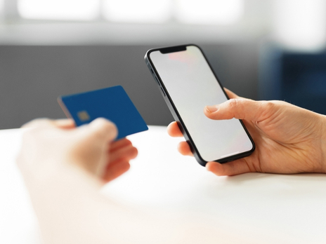 haende mit debitkarte und smartphone